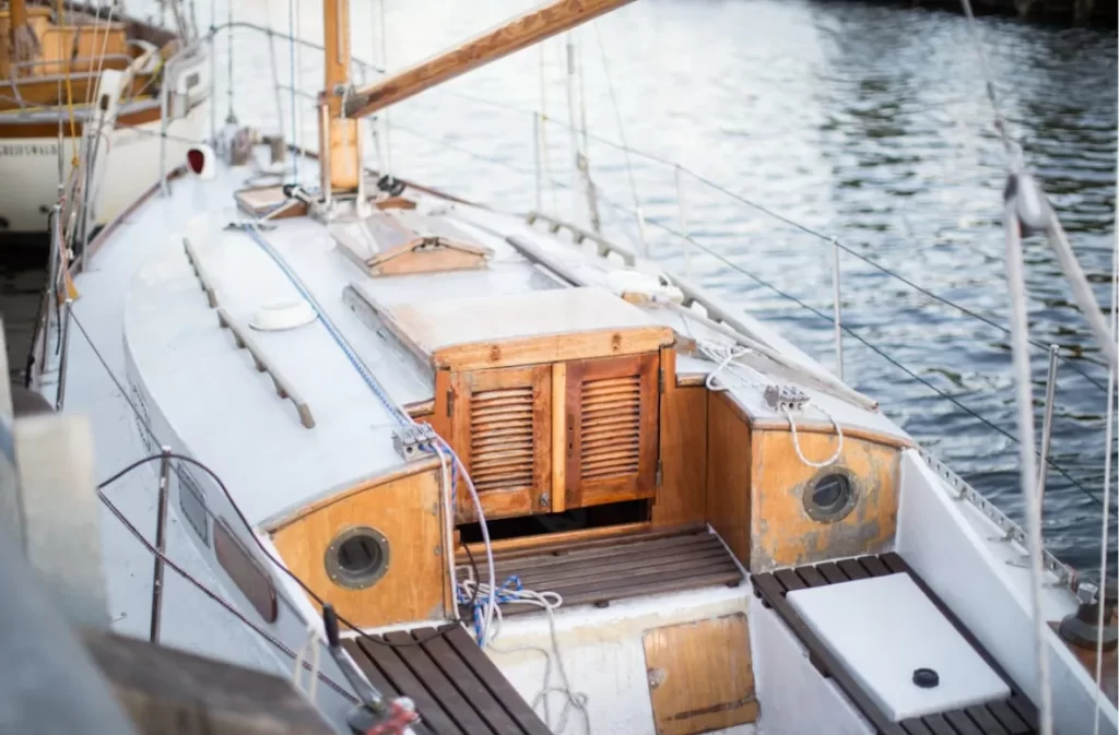 Vintage wooden sailboat with white deck details.