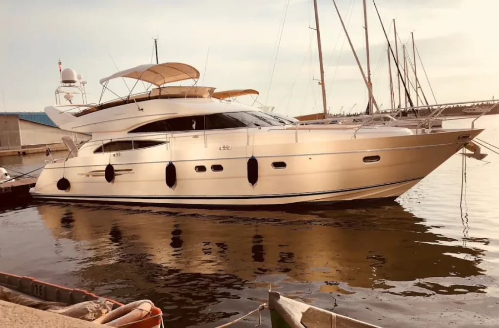 Luxury yacht docked at a marina at sunset.