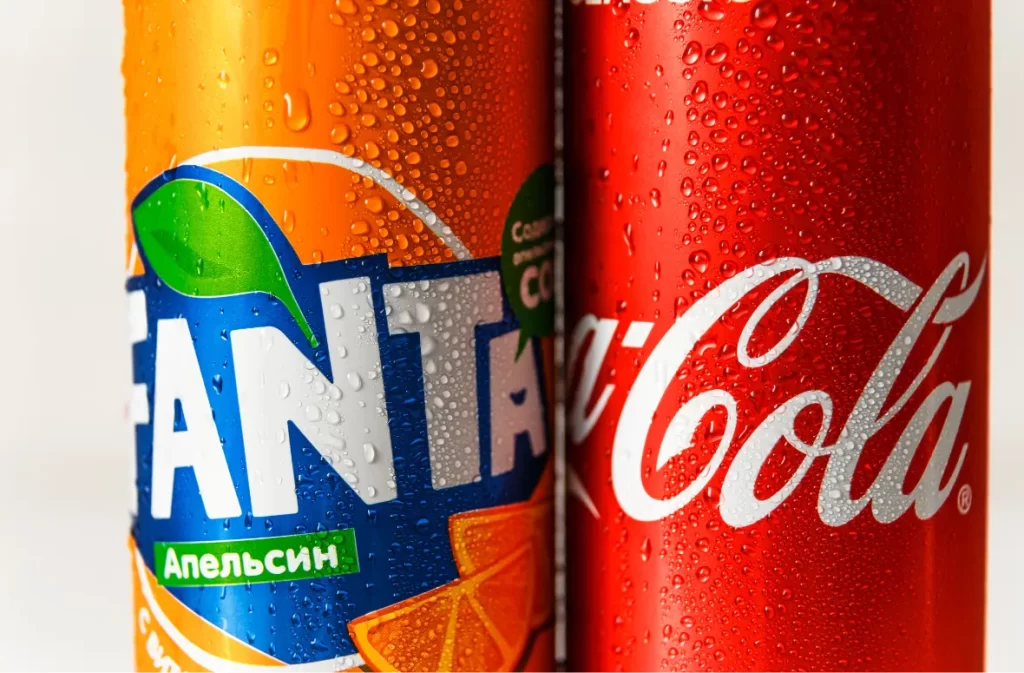 Close-up of Fanta and Coca-Cola cans showing nutrition details.